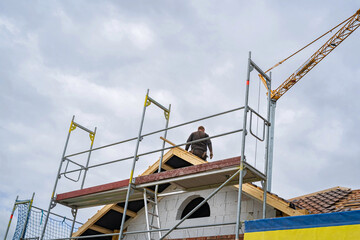 Naklejka premium Wohnhausbau - Dachdeckerarbeiten , Gerüste und Schutznetze sorgen für Sicherheit bei der Arbeit.
