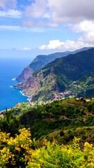 Obraz premium Coastal mountain range with vibrant greenery and clouds