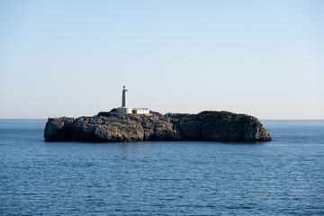 Lighthouse on Rocky Island in Calm Sea