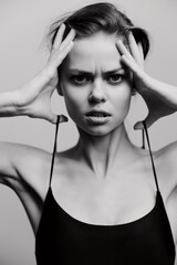 Stressed woman with hands on her head, showcasing intense emotions in a minimalistic black and...