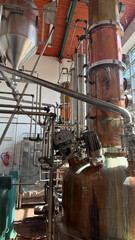 Industrial distillation equipment with copper and stainless steel components in a modern facility