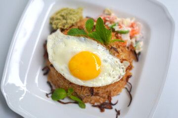 Homemade Biriyani Rice with Spicy Egg Omelet on White Plate.