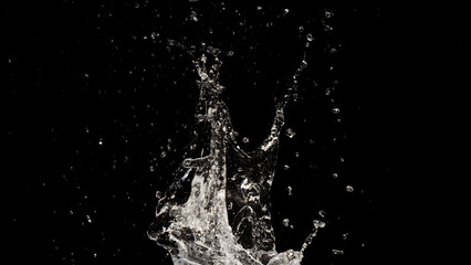 Liquid Splash in the Darkness: A captivating display of water, captured in a moment of dynamic energy, with droplets dancing in the air against a dark canvas.