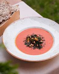 An Artistic and Flavorful Tomato Soup Accompanied by Garnish and