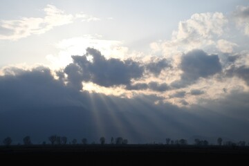 Fototapeta premium Sun rays breaking through clouds