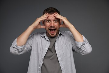 Man suffering from panic attack on grey background