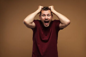 Man suffering from panic attack on brown background