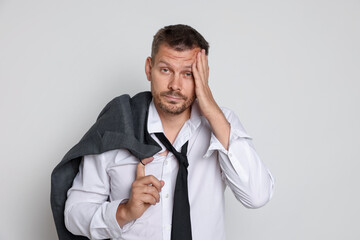 Man suffering from hangover on white background