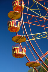 bright yellow-orange ferris wheel against blue sky