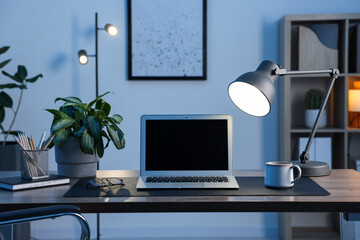 Stylish workplace with modern laptop and stationery on wooden desk indoors
