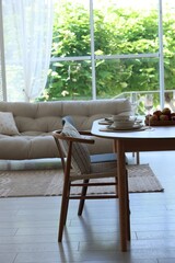 Beautiful table setting, chairs and decor in dining room. Interior design