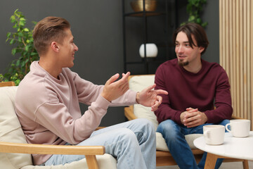 Friends talking while having tea at home