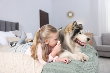 Girl suffering from allergy with her dog on bed at home