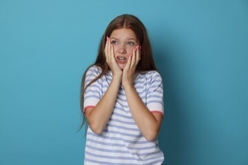 Teenage girl suffering from panic attack on light blue background