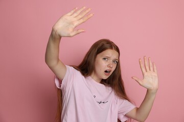 Teenage girl suffering from panic attack on pink background