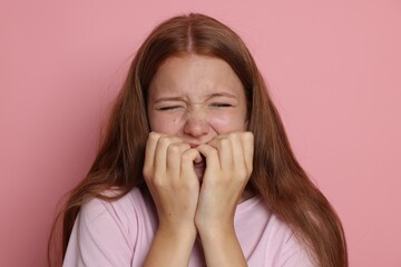 Teenage girl suffering from panic attack on pink background