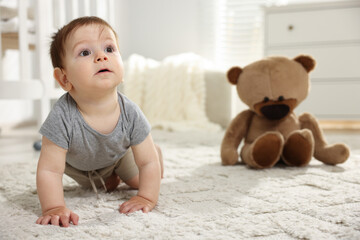 Cute little baby crawling on floor in room
