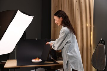 Woman creating composition with tasty pasta in studio. Professional food photography