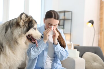 Woman suffering from allergy with her dog at home