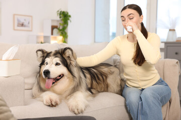 Woman suffering from allergy with her dog at home
