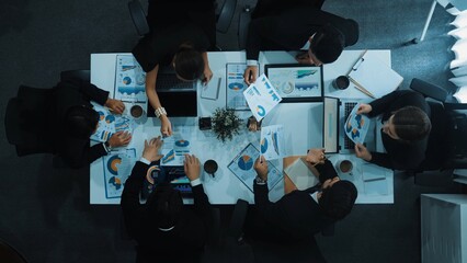 Top view of businesswoman sit at seat and start to analyze stock market data with diverse business team at meeting table with marketing chart document and tablet display financial report. Directorate.