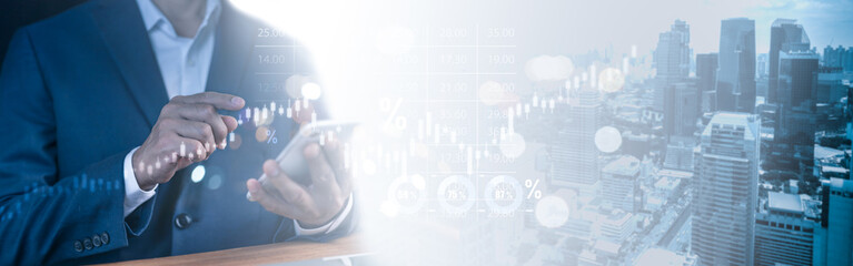 Businessman interacting with futuristic financial graphs on a digital device. Represents stock market analysis, investment strategies, and technology-driven business in an urban environment.