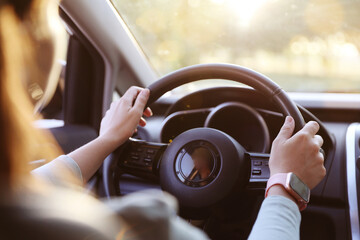 Woman behind steering wheel of modern car, closeup