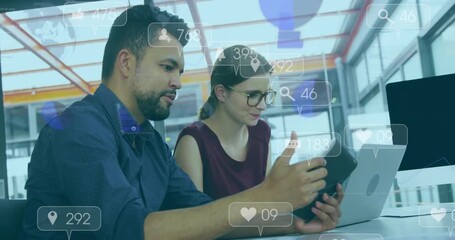 woman tapping tablet while man pointing and monitoring social media engagement with floating icons - Powered by Adobe