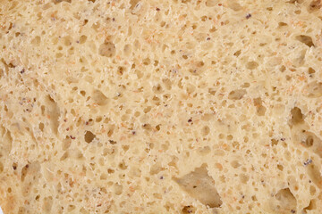 A close-up shot of the porous texture of homemade bread with subtle poppy seeds