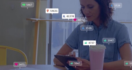 Adult woman tapping tablet and tracking social media badges flooding and receding above cafe table - Powered by Adobe