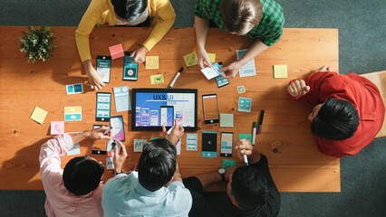 Top view of software developer writing idea about Ux ui design for mobile phone interface. Programmer brainstorm and planning wireframe prototype by looking tablet display smart software. Convocation.