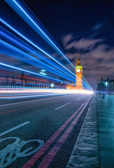 Big Ben at night with the lights of the cars in London city, UK.