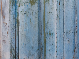 Weathered blue metal wall with rust and peeling paint, showcasing texture and character, ideal for...