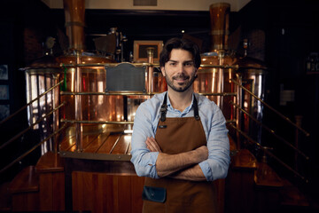 A man dressed in an apron is standing with his arms crossed firmly