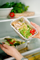 Takeaway healthy food in aluminum foil containers with vegetables and grains.