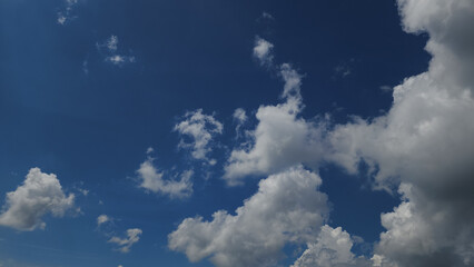 A breathtaking view of a bright blue sky filled with dramatic white clouds, perfect for backgrounds in travel, nature, and inspirational marketing campaigns