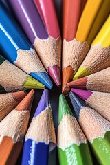 Naklejka premium A detailed macro shot of colorful pencils arranged in a circular pattern with their sharpened tips pointing inward. The pencils display a spectrum of colors from red to violet.