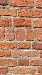 Red brick wall with rough texture and visible cement joints. Concept of construction material, architecture and urban design