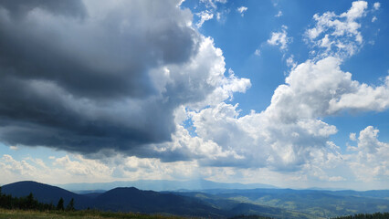 A stunning view of a lush mountain range under a bright blue sky with rolling clouds, perfect for...
