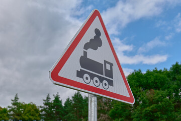 Caution sign for trains displayed in rural area