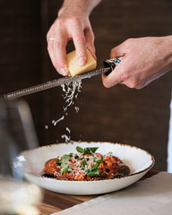 Grating Freshly Made Parmesan Cheese Over a Delicious Pasta Dish