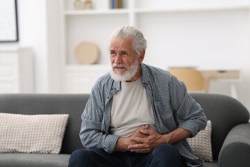 Senior man suffering from stomachache at home