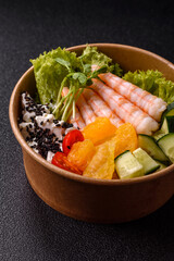 Bowl with shrimps, seafood, rice, oranges, tomatoes with sauce. Bowl with prawns