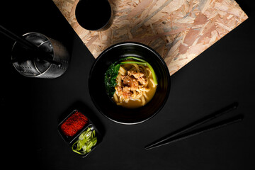 Japanese udon with crispy chicken karaage, fresh greens, and rich broth, served with chili powder...