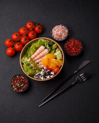Bowl with shrimps, seafood, rice, oranges, tomatoes with sauce. Bowl with prawns