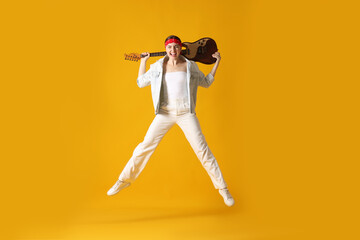 Woman with guitar jumping on orange background