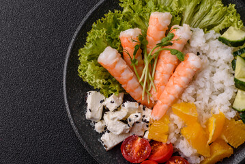 Bowl with shrimps, seafood, rice, oranges, tomatoes with sauce. Bowl with prawns