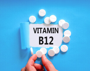 Vitamin B12 symbol. Concept words Vitamin B12 on beautiful white paper. White pills tablets....