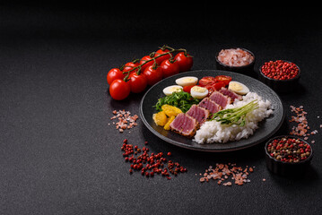 Seafood bowl, tuna tataki fillet slices with rice, oranges, tomatoes and sauce. Tuna bowl