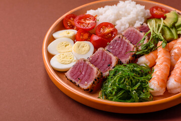 Seafood bowl, tuna tataki fillet slices with rice, oranges, tomatoes and sauce. Tuna bowl